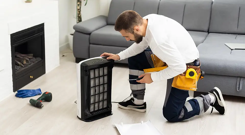 HVAC technician changes a home's HEPA filter.