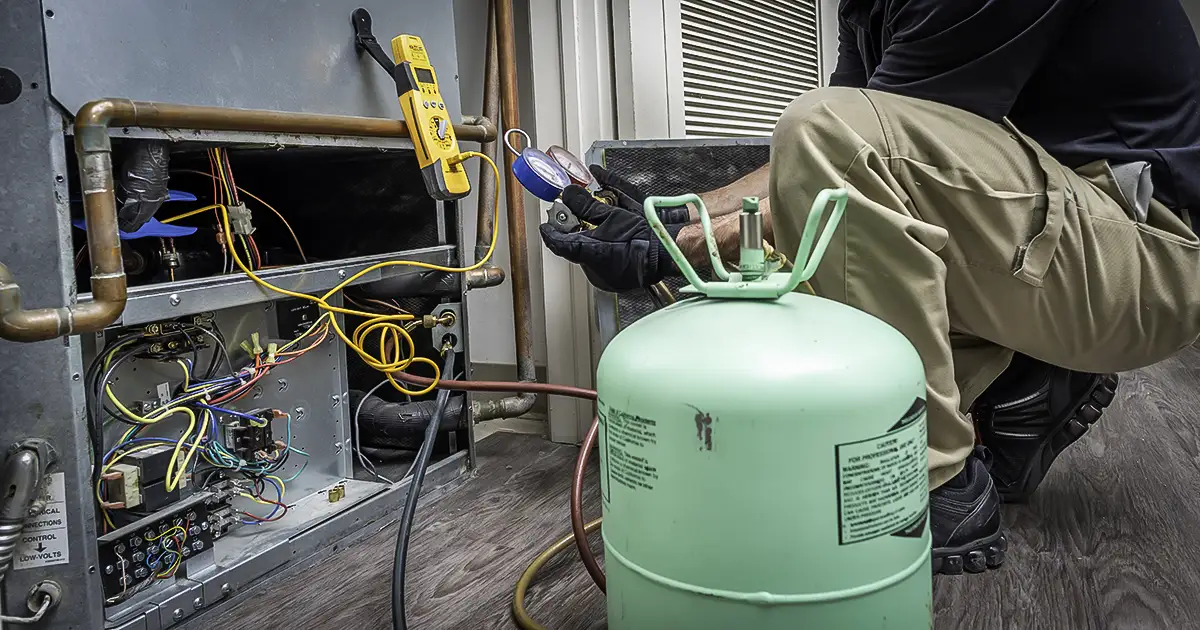 An HVAC tech refills a customer's refrigerant in their air conditioner.