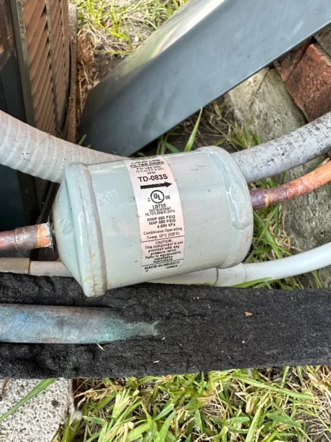 HVAC technician's vacuum pump connected to refrigerant lines during system evacuation and recharge in Rowlett, TX