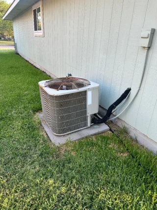 New R454B heat pump unit installed on concrete pad against white residential siding in Mesquite, TX