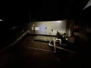 New R454B heat pump system installed at night on concrete pad with connecting refrigerant lines visible