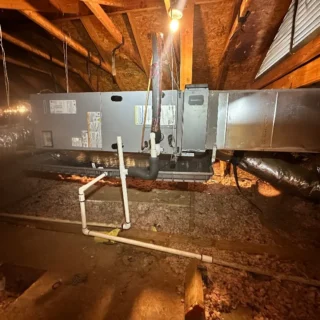 New R454B heat pump system installed in Mesquite attic with ductwork and refrigerant lines connected