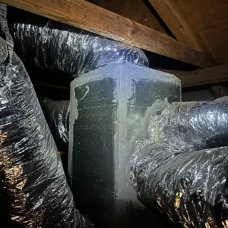 HVAC ductwork wrapped in insulation inside attic space with wooden beams in Mesquite home