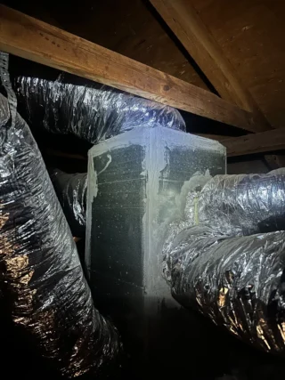 HVAC ductwork wrapped in insulation inside attic space with wooden beams in Mesquite home