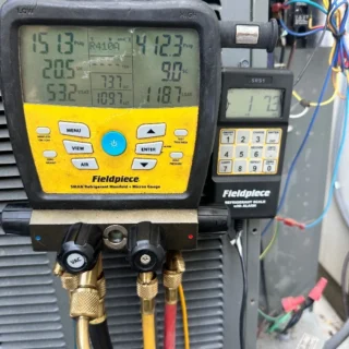HVAC technician using Fieldpiece manifold gauge and refrigerant scale to diagnose air conditioning system failure in Mesquite