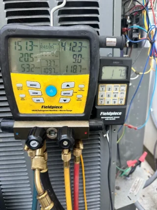 HVAC technician using Fieldpiece manifold gauge and refrigerant scale to diagnose air conditioning system failure in Mesquite