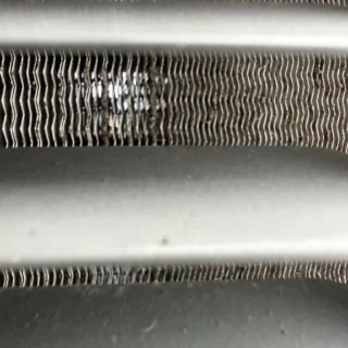 Heavily soiled HVAC condenser coil fins clogged with dirt and debris causing system lockout in Mesquite home