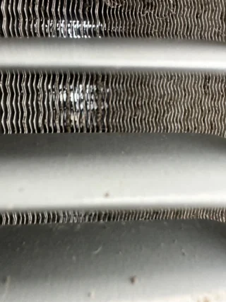 Heavily soiled HVAC condenser coil fins clogged with dirt and debris causing system lockout in Mesquite home