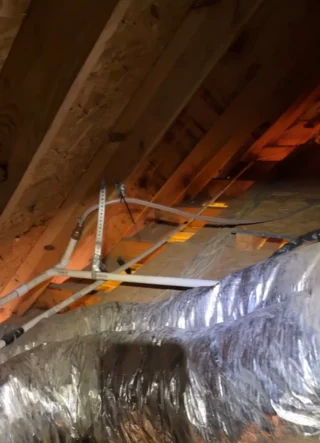 New condensation drain hose rerouted and secured to attic framing with improved termination routing